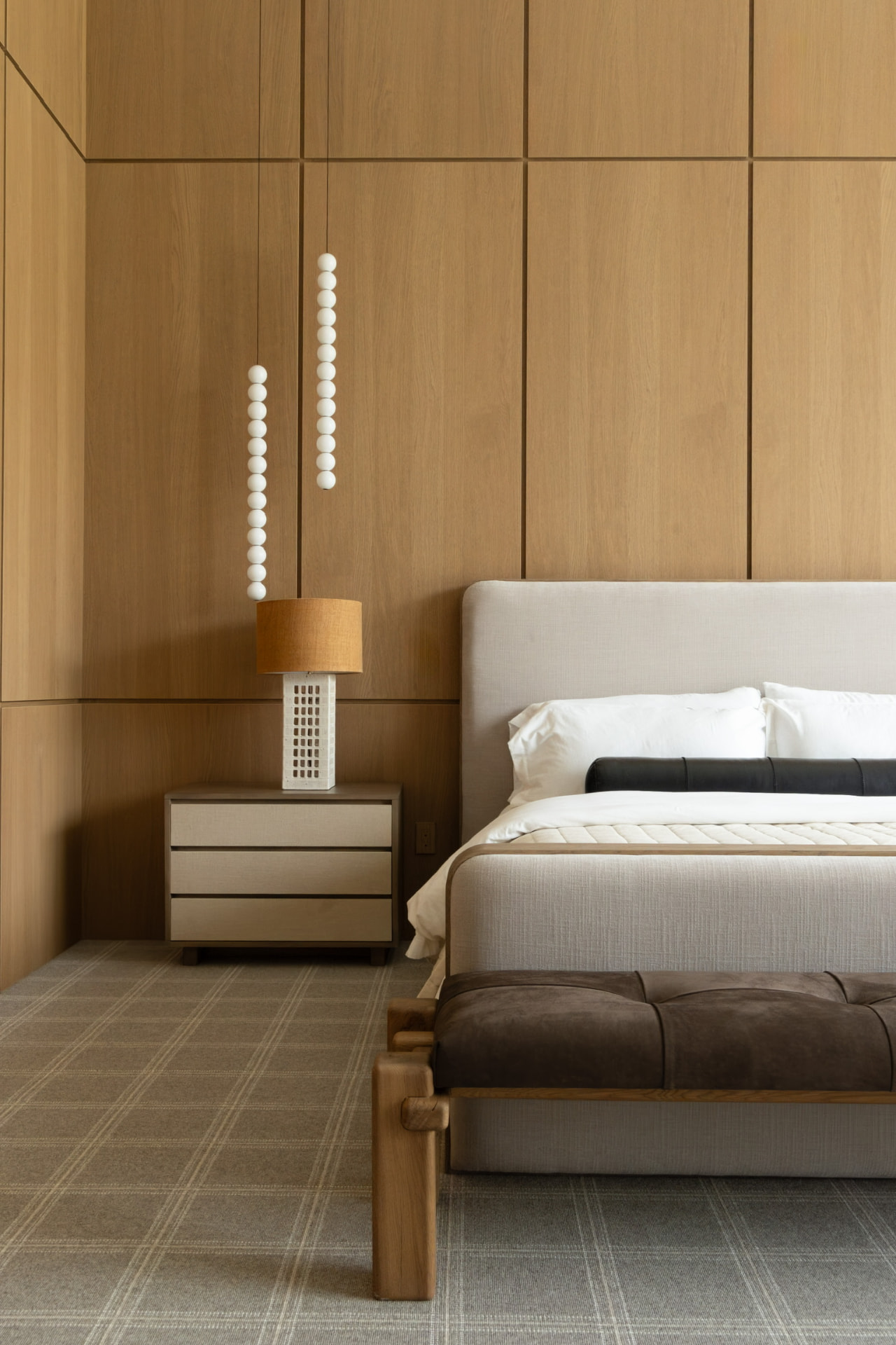 Bedroom with wood paneled walls and beaded pendants