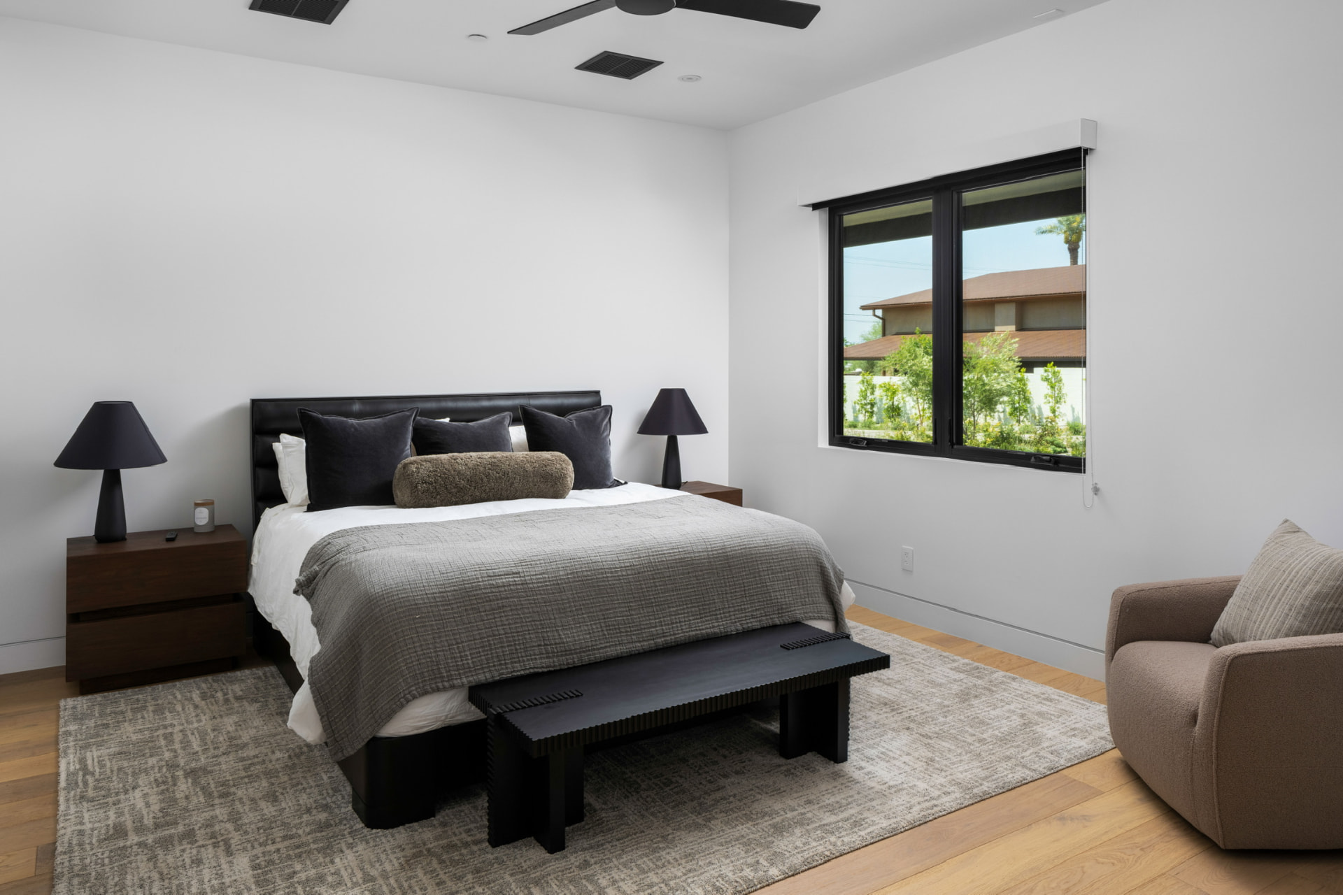 Guest bedroom with black bed and lounge chair