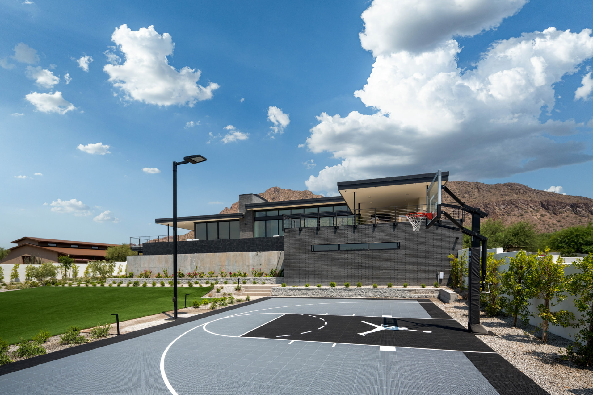 Basketball court with the residence and mountain beyond
