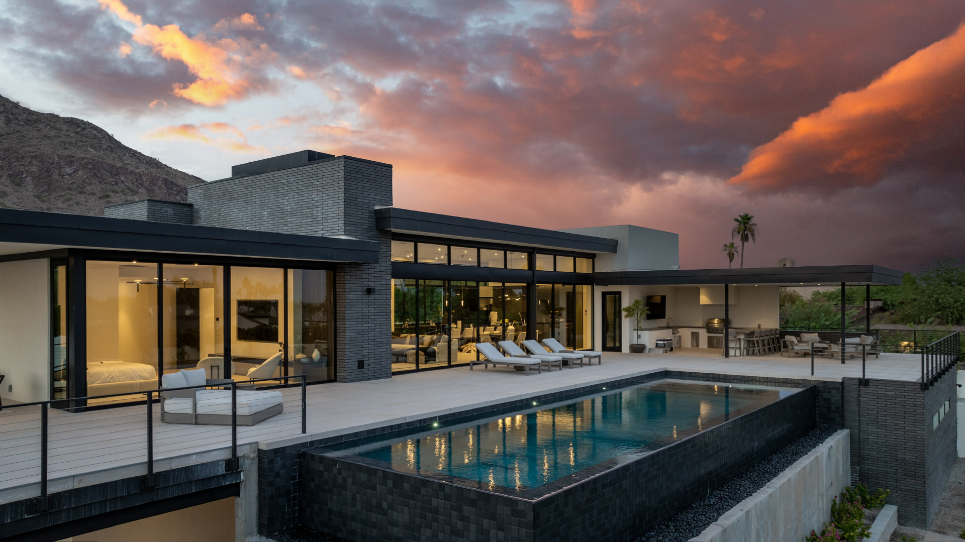Elevated infinity pool and illuminated residence at sunset
