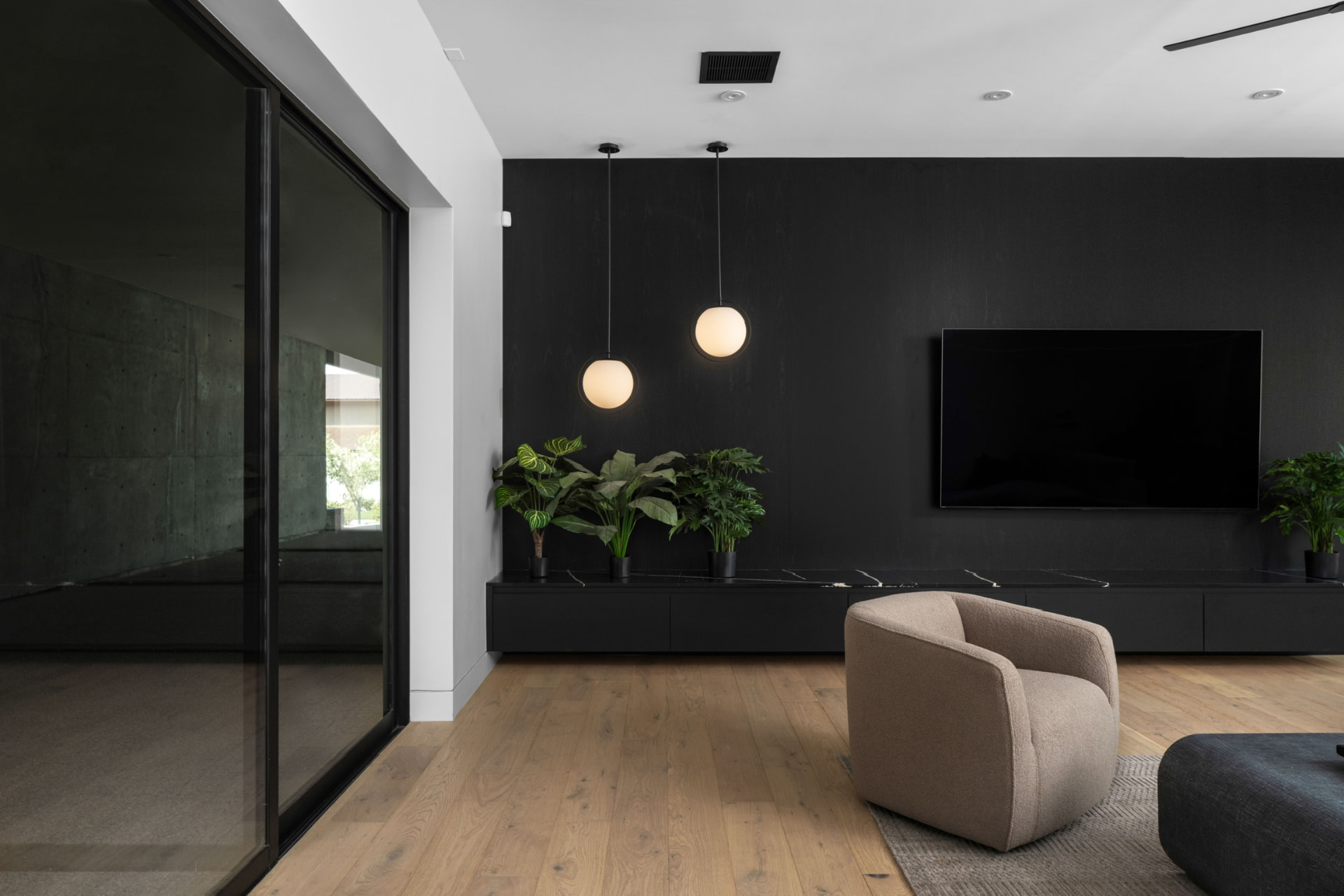 Media wall with floating cabinetry and globe pendants