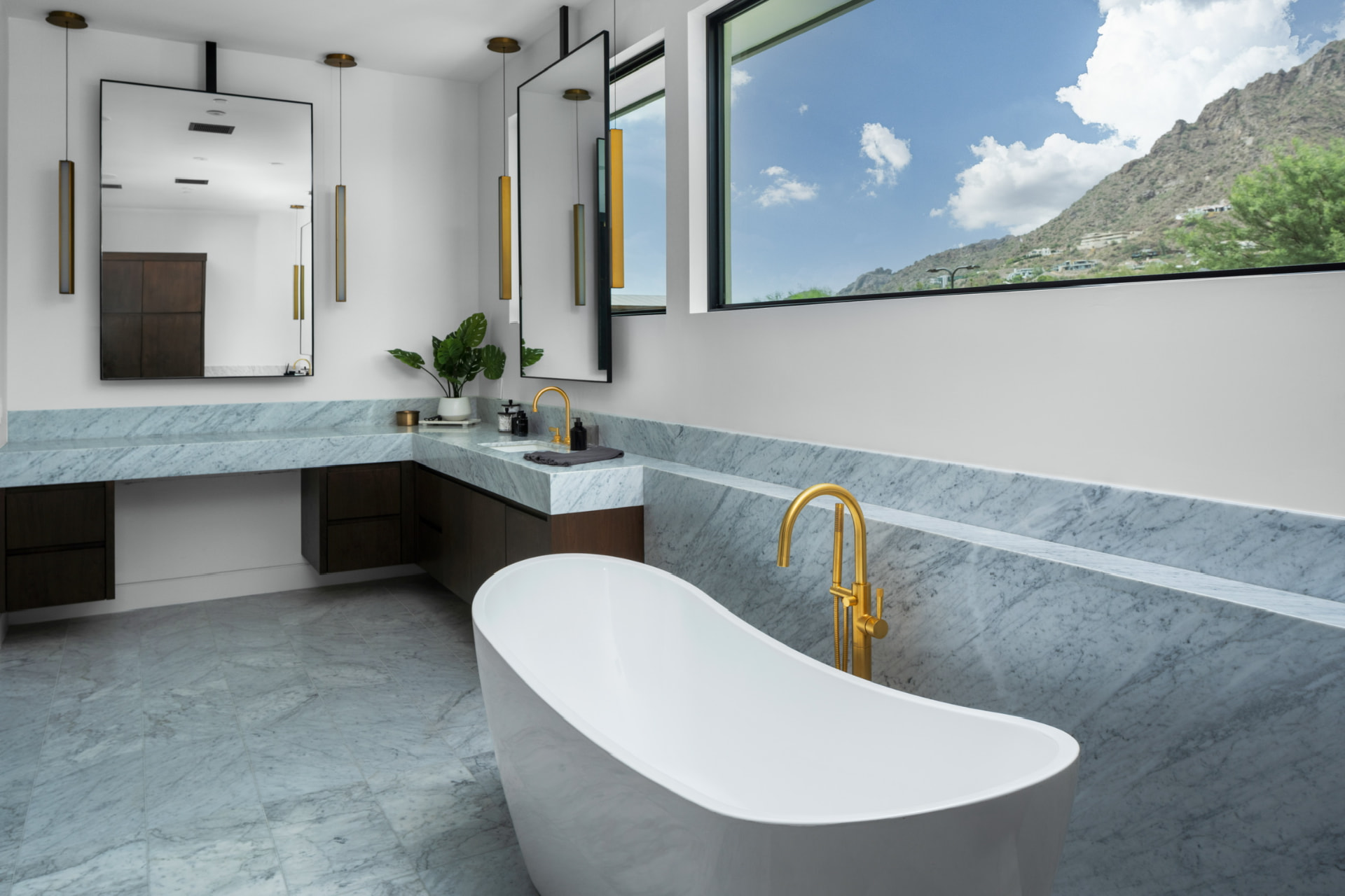 Marble bathroom with brass fixtures and mountain views