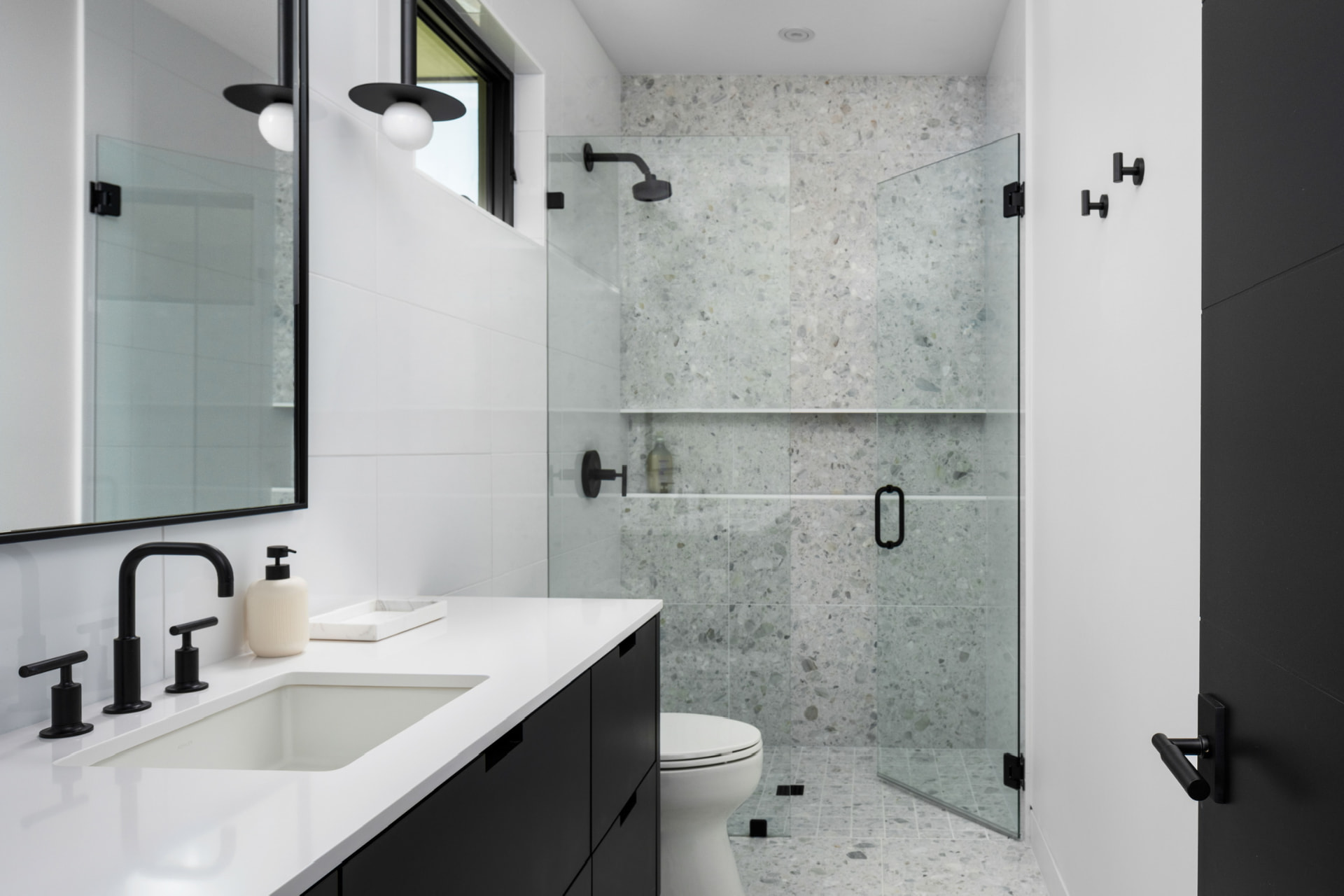 Guest bathroom with stone shower and black fixtures