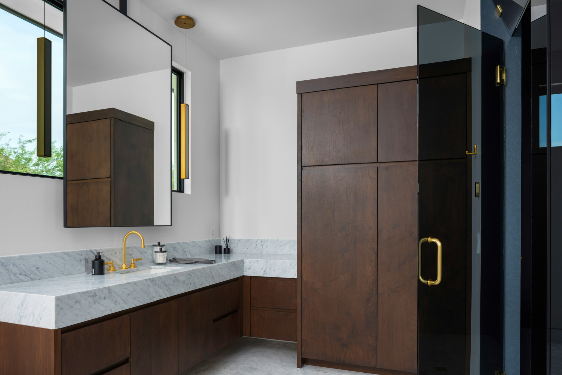 Marble vanity with wood cabinetry and brass accents