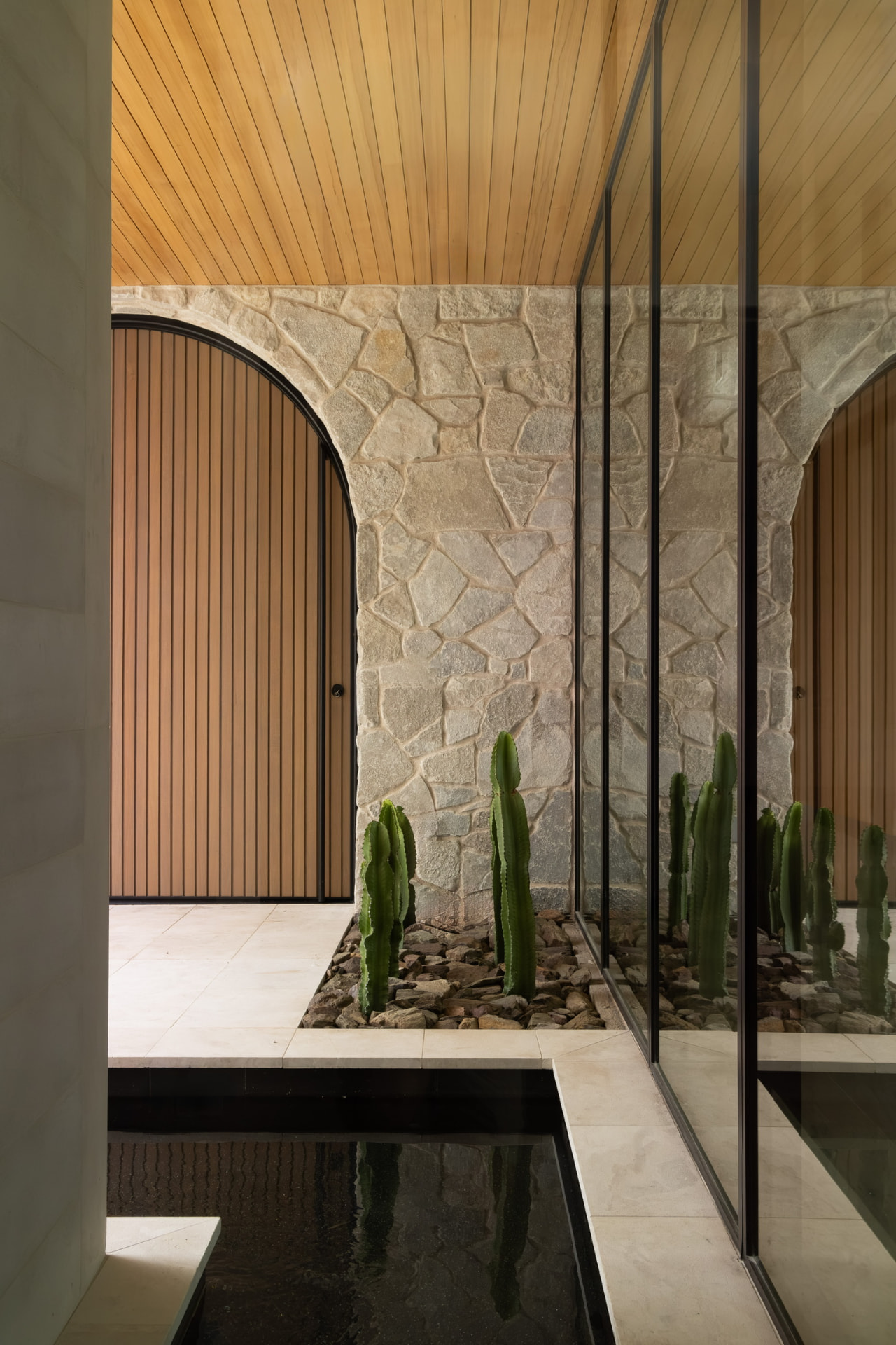 Arched stone entry with cactus garden and reflecting pool