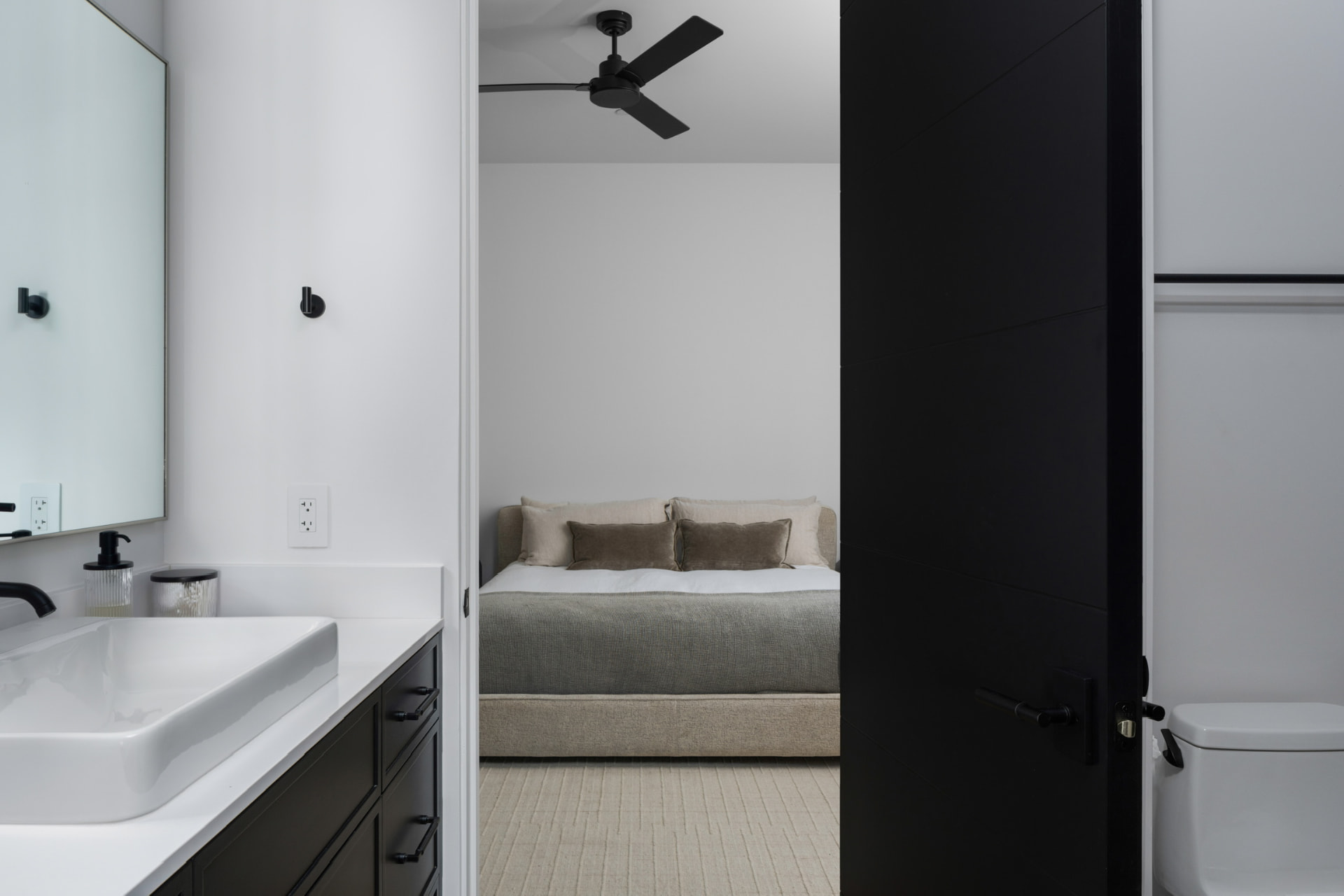 Guest bathroom opening to an upholstered bedroom