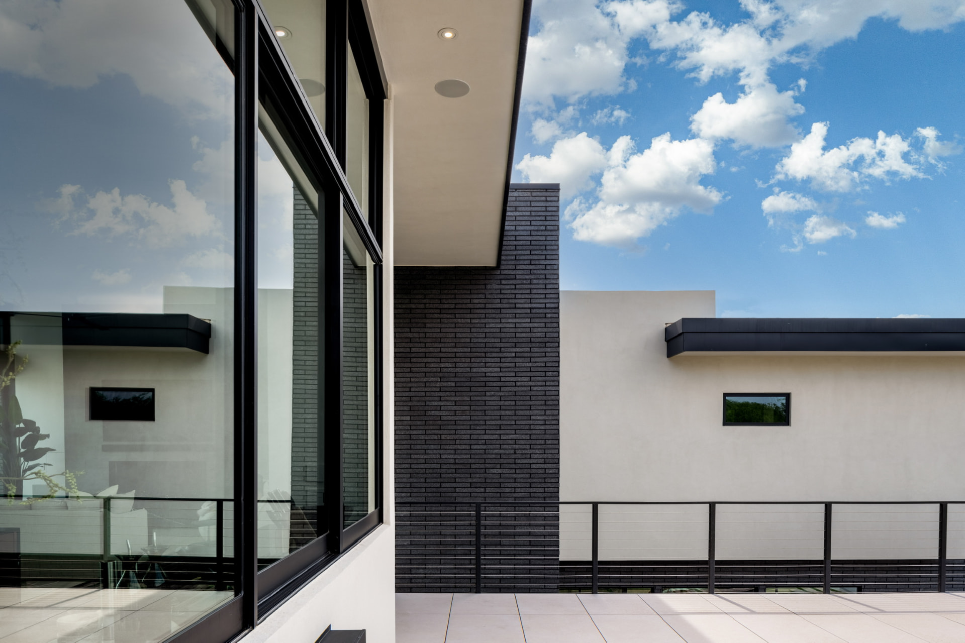 Upper terrace with glass walls and black brick