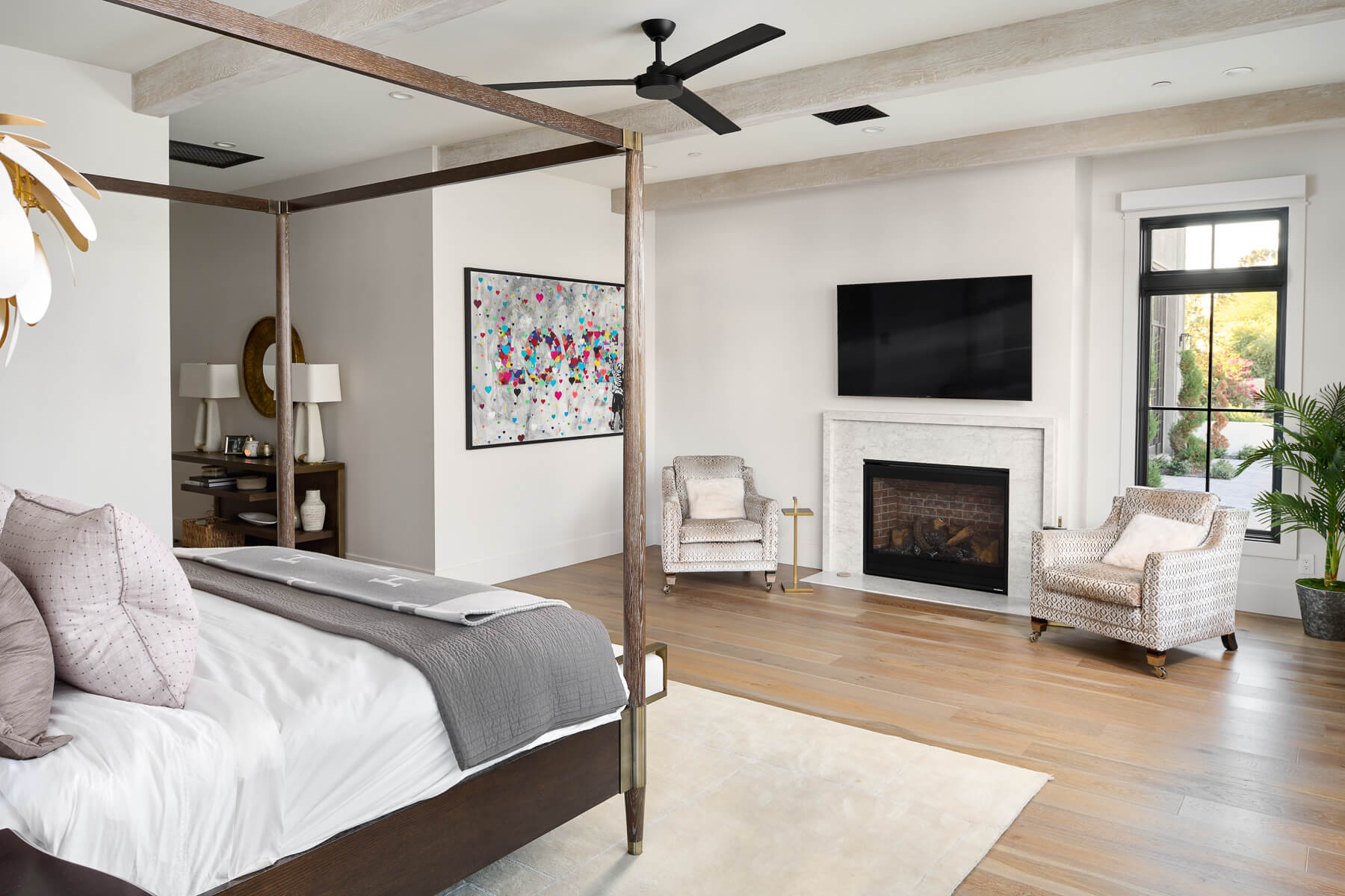 Primary suite with canopy bed and fireplace