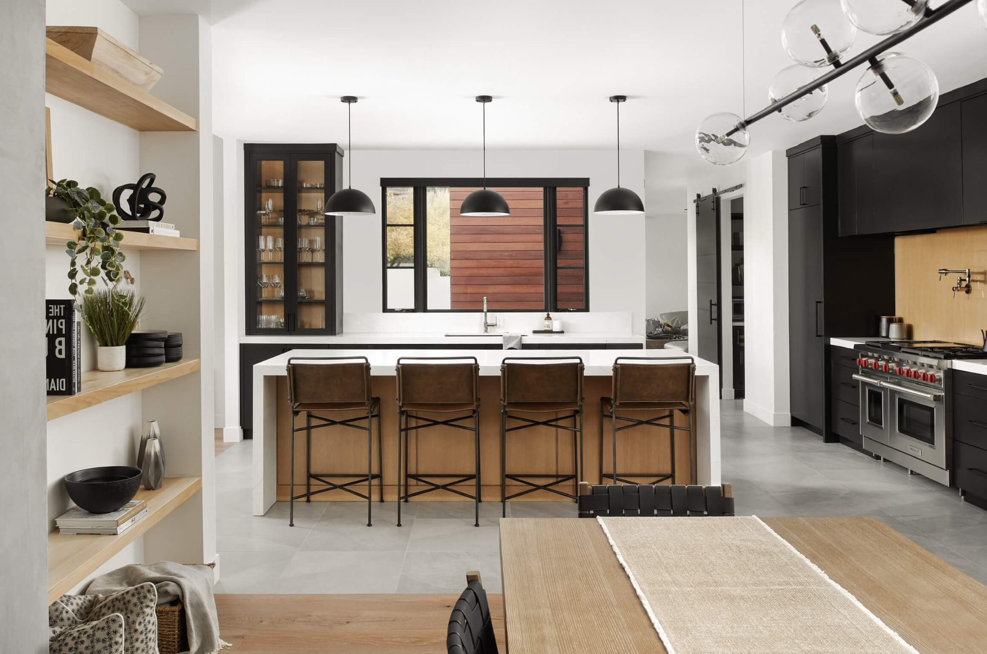 Kitchen with black cabinetry and oak island