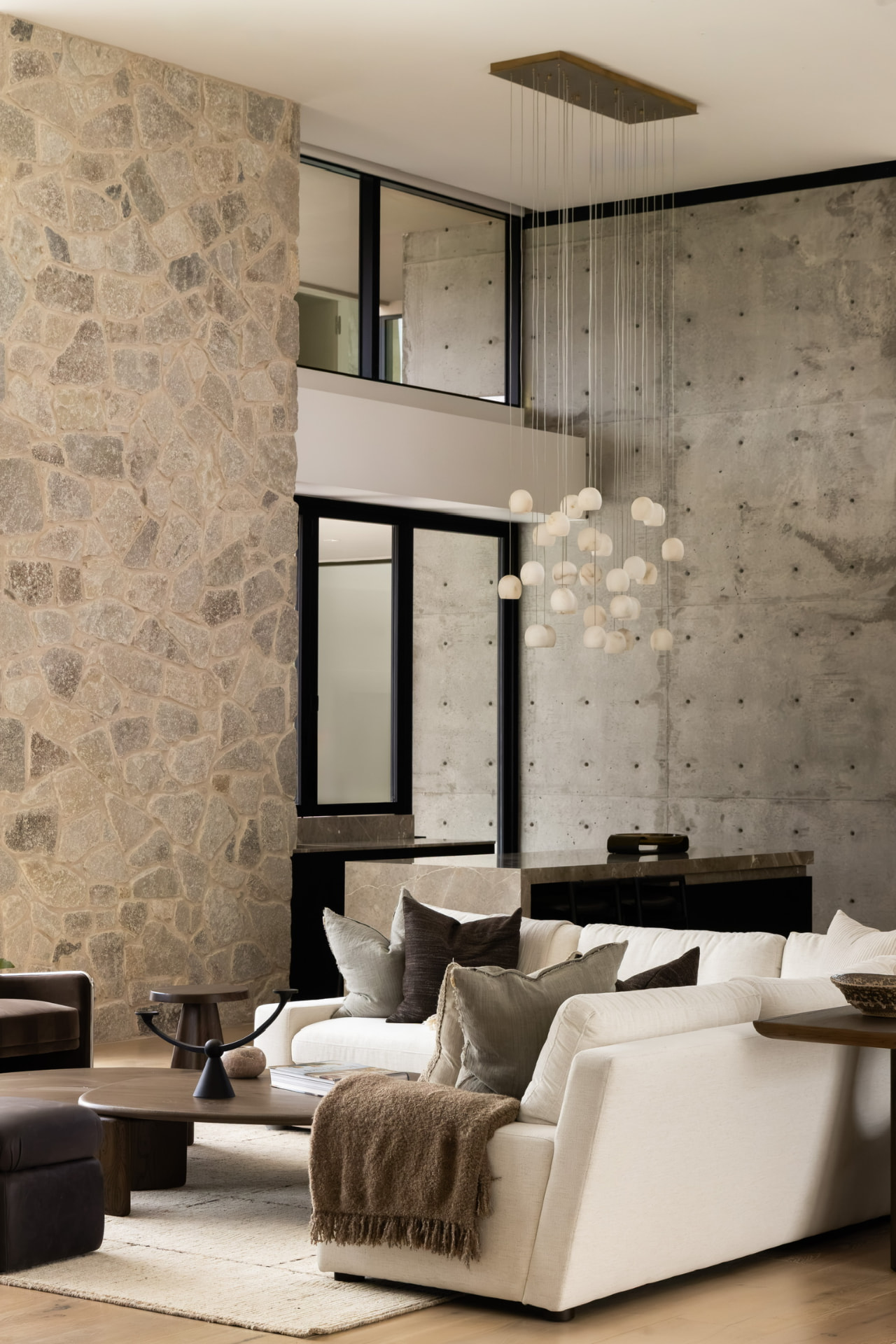 Living room with stone wall and cascading globe chandelier