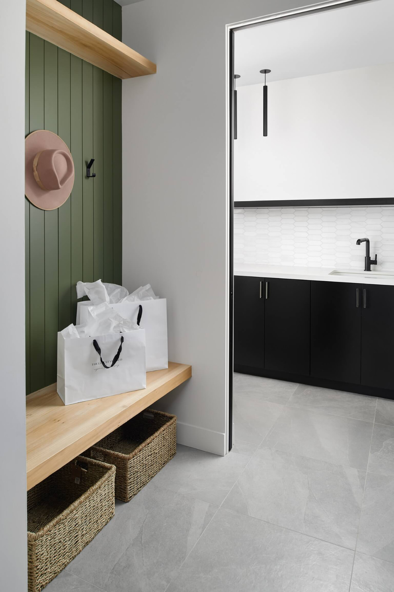 Mudroom with green panel walls and bench