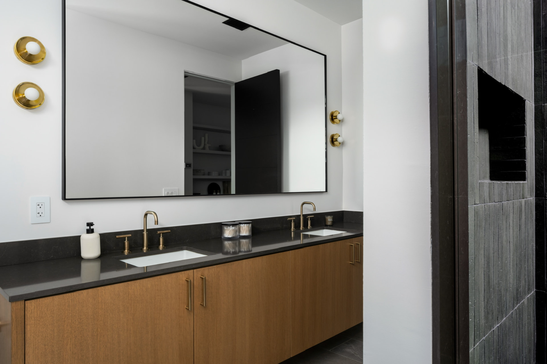 Double vanity with oak cabinetry and brass fixtures