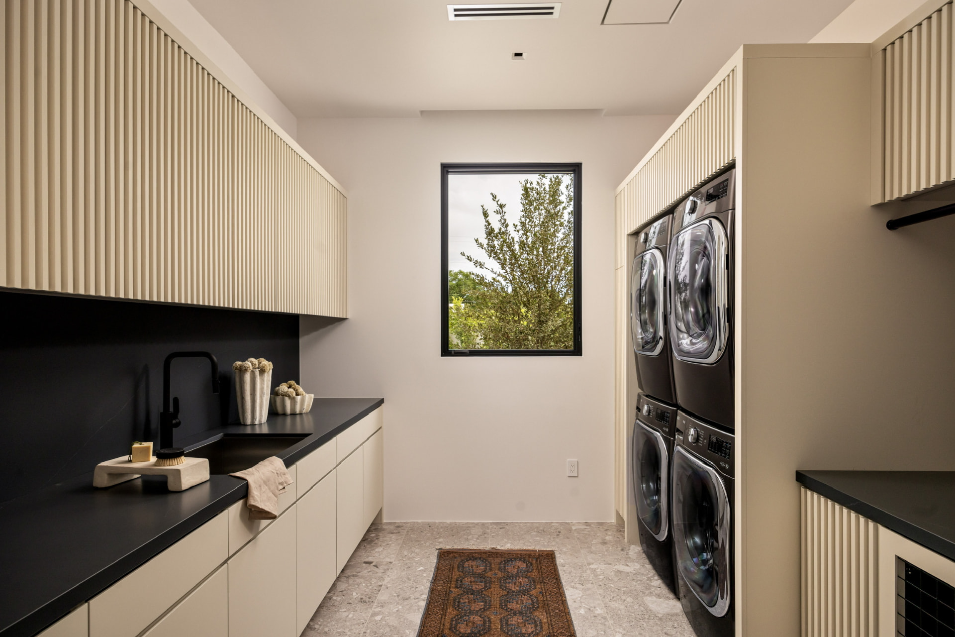 Laundry room with fluted cabinetry and garden window