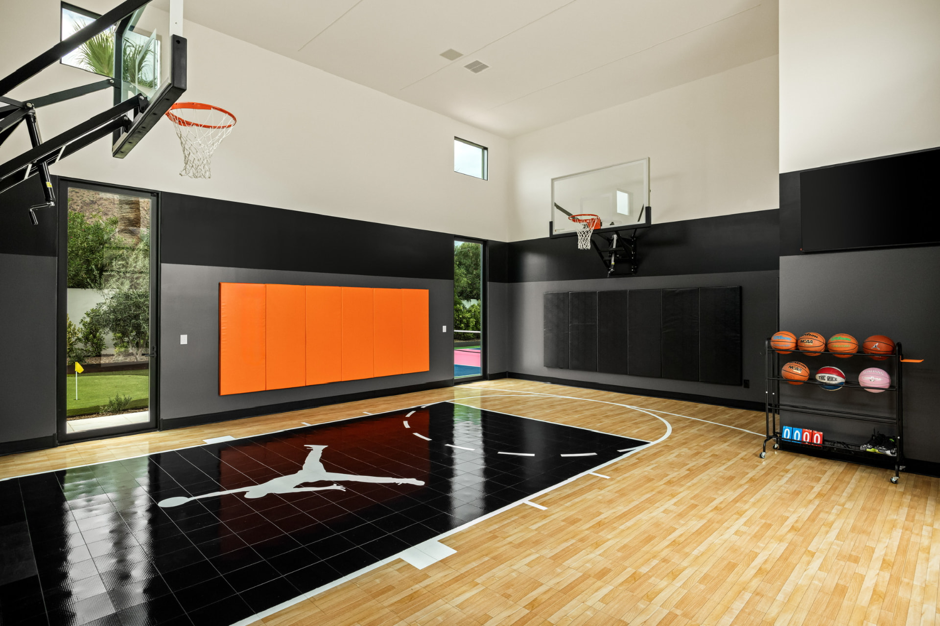Indoor basketball court with glass walls to the garden