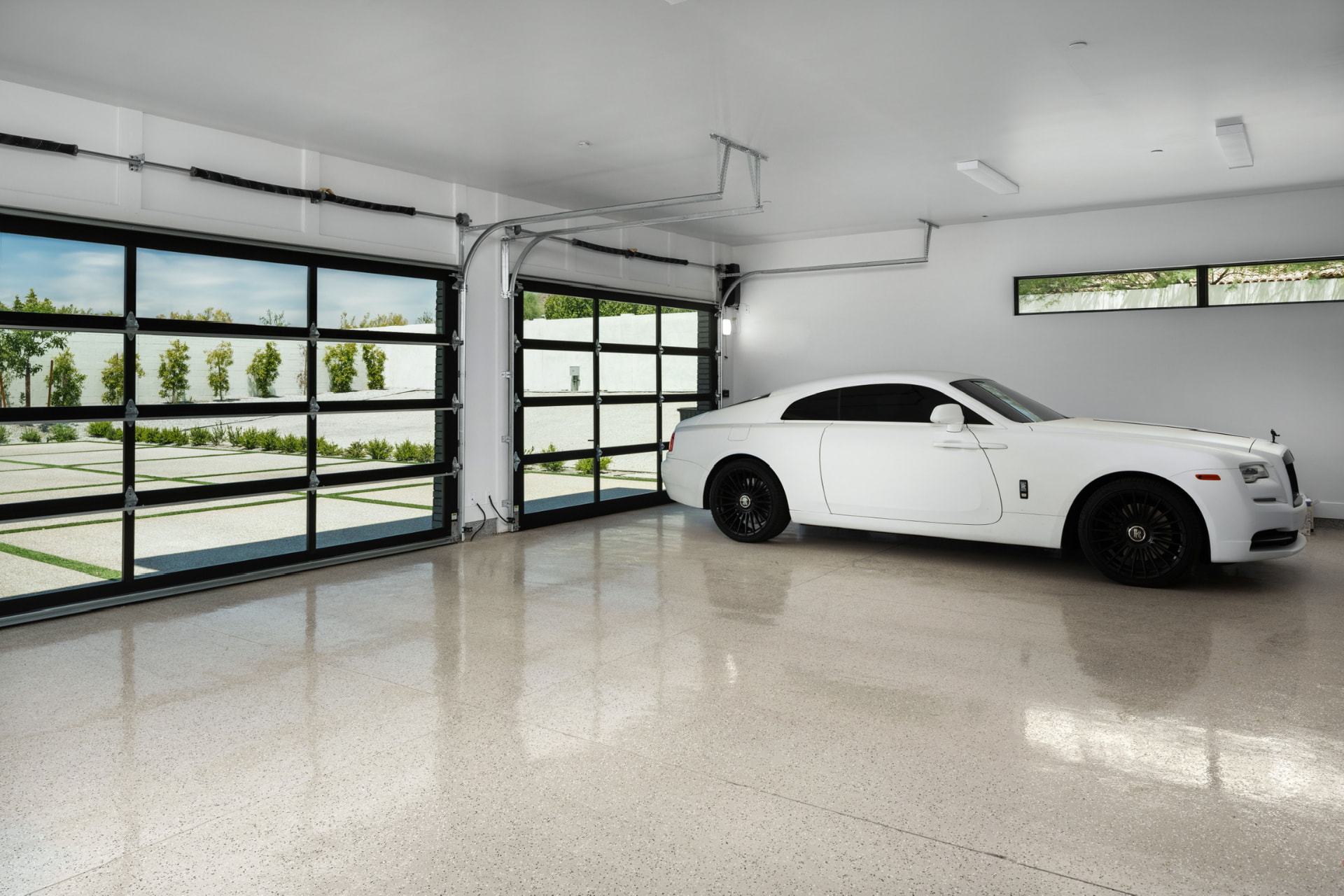 Glass-door garage with white coupe