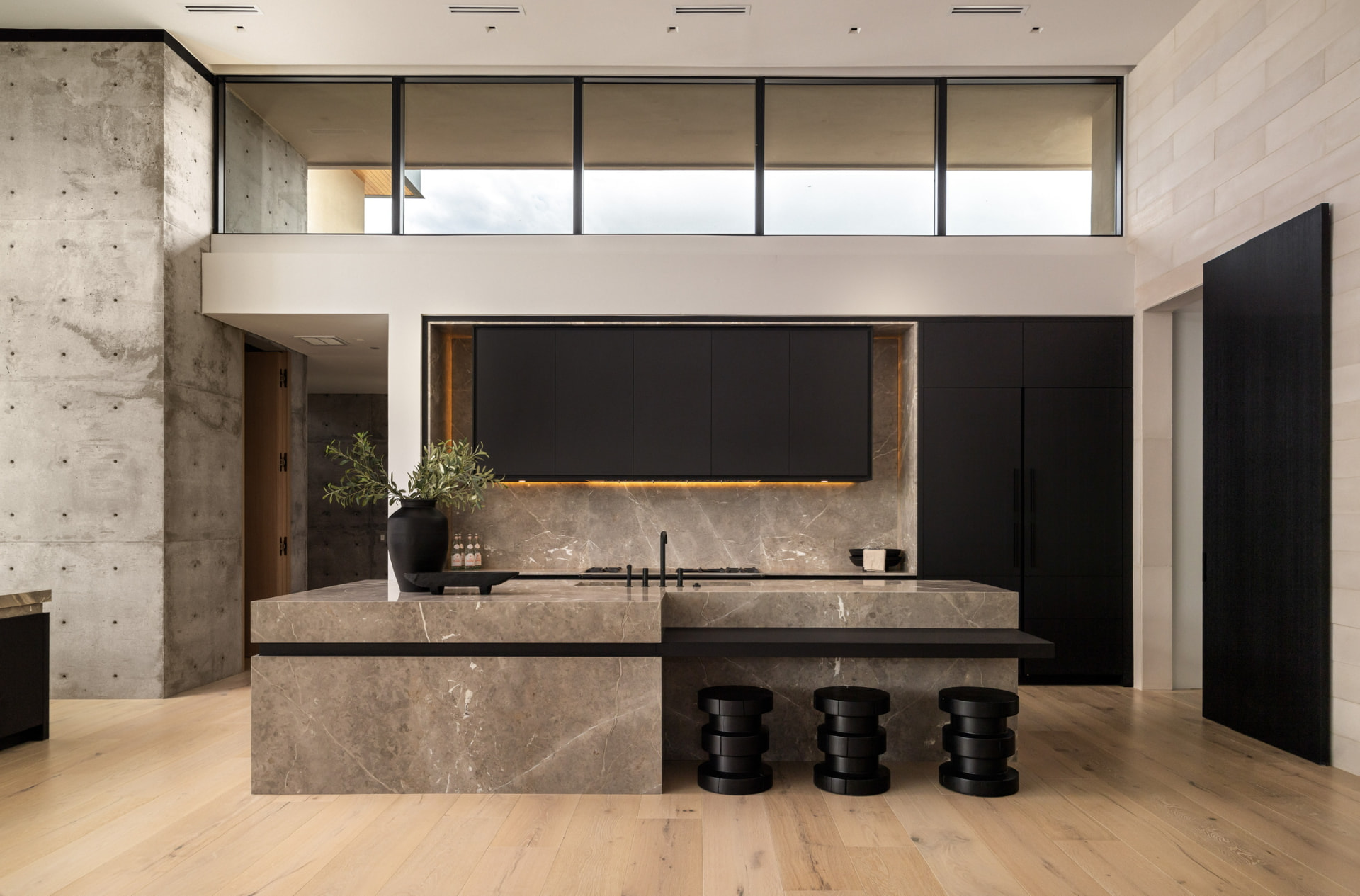 Kitchen with marble island and matte black cabinetry